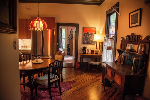 A dining area with wooden furniture, a chandelier, and a view into the kitchen. - Miss Scarlet 3-bedroom cottage in Historic downtown Hot Springs (Hot Springs)
