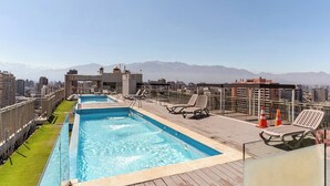A rooftop pool with lounge chairs and a city view. - Apartment in Metro U. de Chile with Balcony, Gym & Swimming Pool, Historic Center Santiago (Santiago)