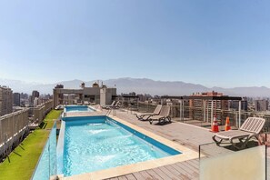 Pool auf dem Dach mit Liegestühlen und Blick auf die Stadt.