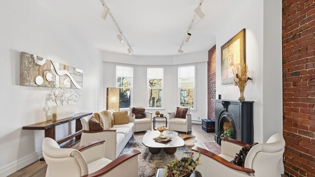 A spacious living room with a fireplace, large windows, and modern furniture. - Stylish Heritage Stay in Downtown Halifax (Halifax)