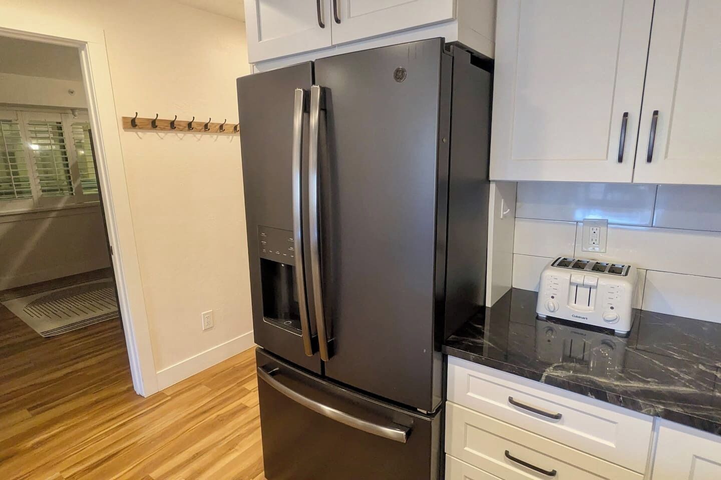 A kitchen with a stainless steel refrigerator, a built-in oven, and a white countertop.