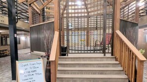 A staircase with wooden railings and a sign indicating quiet hours and hot tub hours.