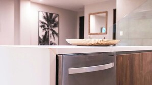 Una cocina moderna con un refrigerador de acero inoxidable, un gabinete de madera y un cuenco decorativo encima.
