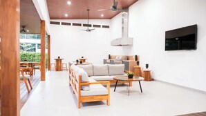 Un amplio espacio de sala con un sofá, una mesa de centro y una televisión.