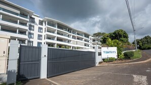 Un hotel a più piani dal design moderno, con balconi su ogni piano e un ingresso recintato.