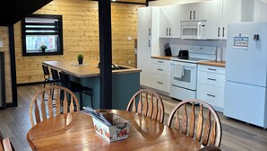 Una cocina moderna con armarios blancos, un microondas y un refrigerador.