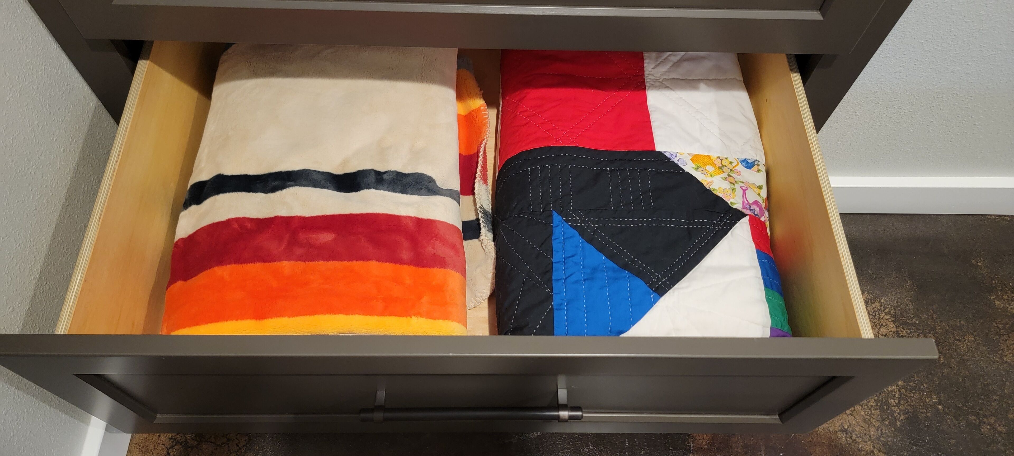 Un cajón con diversas telas y textiles.