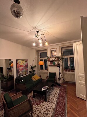 A living room with a sofa, chairs, a coffee table, a floor lamp, and a painting on the wall. - 2-Bedroom Apartment in the Heart of Vienna   (Altersgrund)