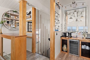Eine moderne Küche mit Holzelementen, einer integrierten Kaffeestation und Meerblick.