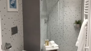 Een moderne badkamer met toilet, wastafel en douchehoek.