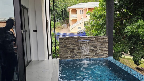 Una piscina interior moderna con pared de piedra y valla azul.