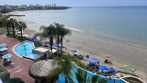A resort with a swimming pool, beach, and palm trees. - Oceánica Luxury Apartment (Salinas)