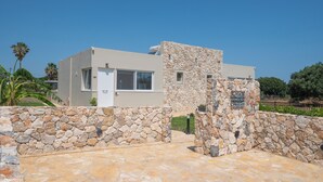Un edificio moderno con fachada de piedra y un letrero que dice 'Stone & Sea'.
