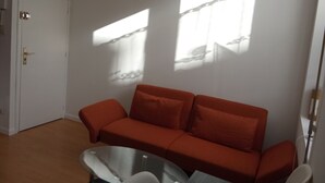 A room with a red sofa, a glass coffee table, and a white door. - Lille Centre Lille Europe station (Lille)