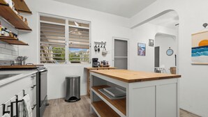 A modern kitchen with white cabinetry, wooden countertops, and a window with blinds. - Unique 2-Home Family Getaway Near Beaches Airport Restaurants.  Ideal for Groups (Arenales)