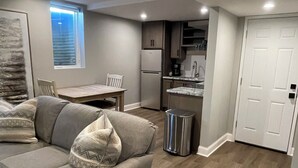 Un salon moderne comprenant un canapé, une table à manger et un coin cuisine.
