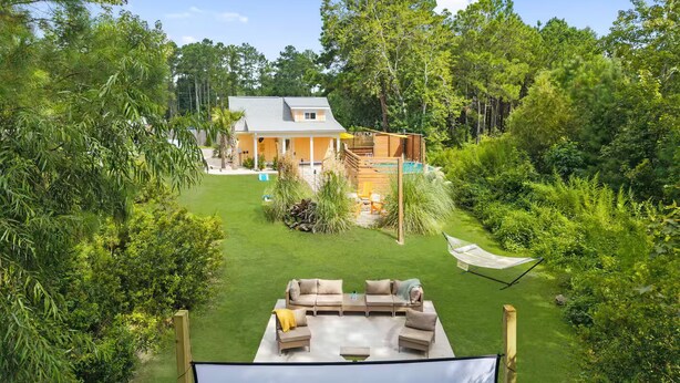 A house with a large backyard, a swimming pool, and a deck area. - Ocean Isle Retreat (Ocean Isle Beach)