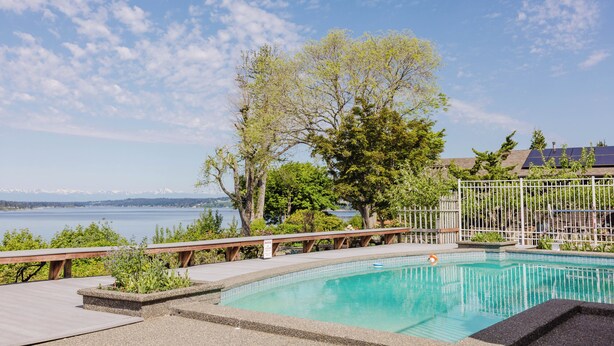 A swimming pool with a view of a lake and mountains in the background. - The Folly PLUS, University Place View Home with Pool, Perfect  for Celebrations. (University Place)