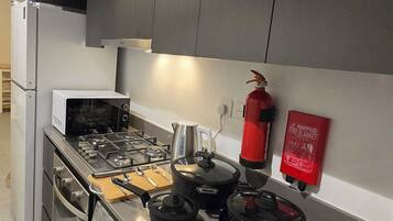 Estúdio superluxo, vista para o pátio | Cozinha privada | Geladeira grande, micro-ondas, fogão, cooktop