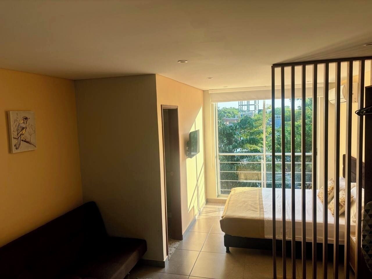 Un dormitorio con una cama, una ventana y un balcón.