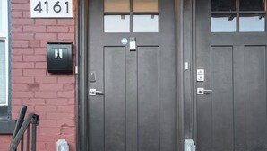 Entrada dupla com placa numérica '4161' e tapete de boas-vindas nos degraus.