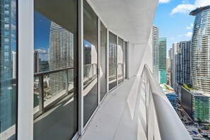Un bâtiment moderne doté de grandes fenêtres et d’un balcon donnant sur un paysage urbain.