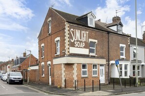 A two-story brick building with a sign that reads "SUNLIGHT SOAP" on the side. - Central 5 Bedroom Home Close to Gloucester City (Gloucester)
