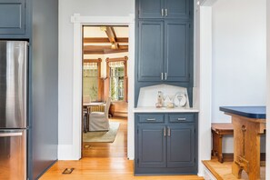 A modern kitchen with dark blue cabinets, a stainless steel refrigerator, and a wooden dining table. - 4000 sf 5br house w/ yard 5 min to Space Needle/Pike Mkt 1 blck to Queen Anne Av (Seattle)