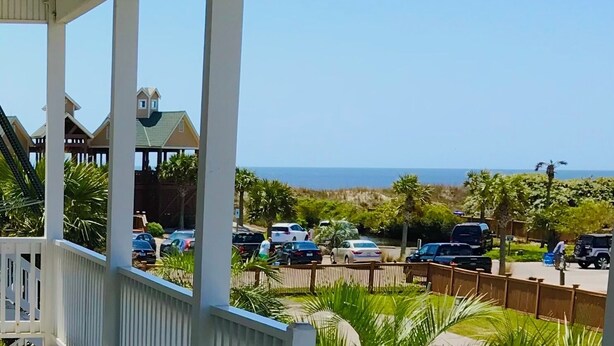 Une vue sur la côte, avec une plage, des voitures garées et un bâtiment doté d’un porche.