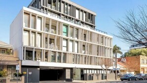 Un edificio moderno con techo plano, ventanas amplias y una entrada visible.