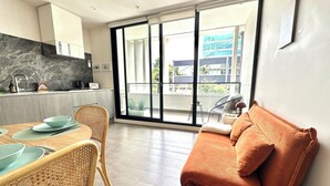 Una cocina moderna con comedor, ventanas amplias y un balcón.