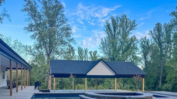 A patio area with Adirondack chairs, a fire pit, and a covered seating area. - New! Secluded Farmhouse Pool + Firepit 14ppl (Faber)