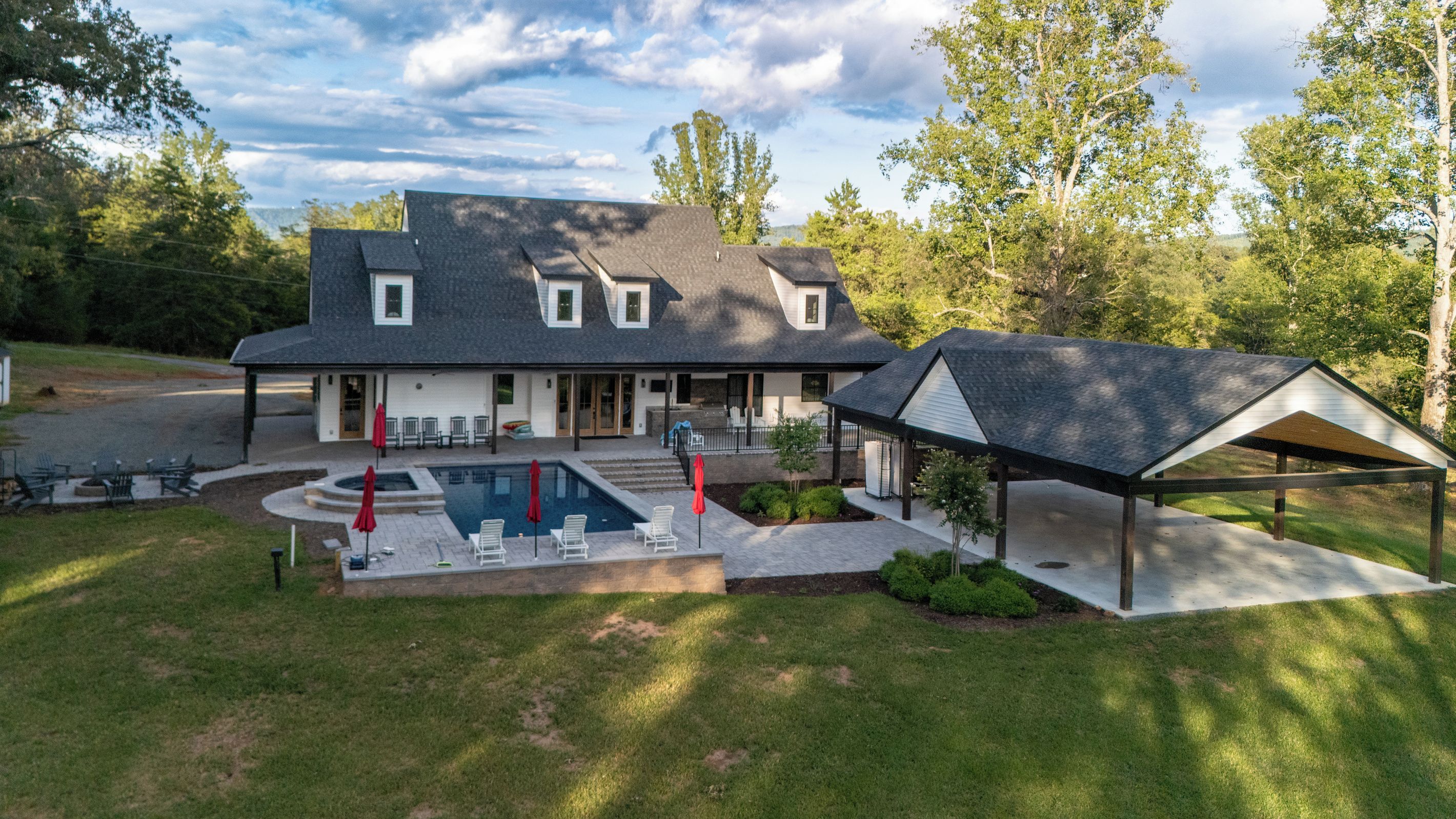 A two-story house with a swimming pool, covered patio, and a fenced yard.