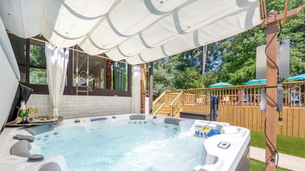 Un jacuzzi con cubierta de madera y zona techada.