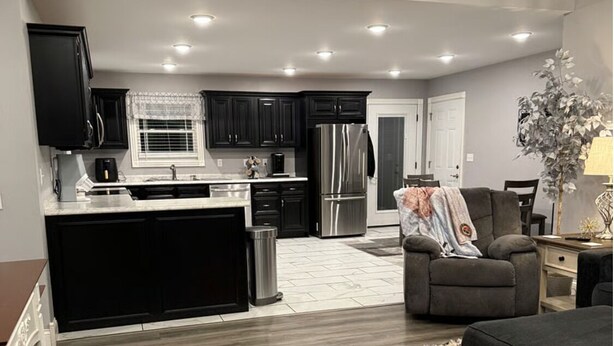 A modern kitchen with dark cabinets, stainless steel appliances, and a central island. - The Gilliam House (london)