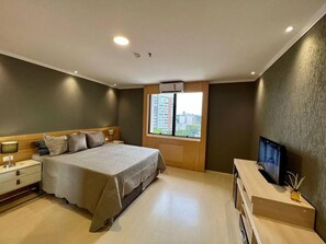 A hotel room with a bed, bedside table, TV, and a window with a view. - Luxury suite 5 minutes from Congonhas Airport, queen-size bed + single bed (São Paulo)