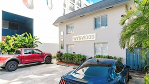 Un edificio con il cartello "WYNWOOD" e un camion rosso parcheggiato davanti.
