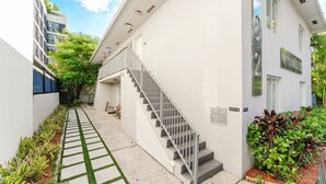 Un edificio moderno con una scala che conduce all'ingresso, un percorso accessibile e un'area giardino curata.