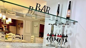 Eine moderne Küche mit Marmorarbeitsplatte, einem Weinkühler und einer Bar mit Glastrennwand.