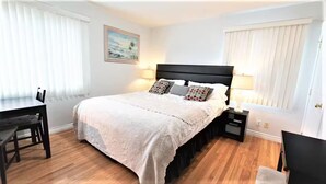 A bedroom with a bed, bedside tables, a desk, and a chair. - 3-bedroom house, pool and other amenities in amazing Tarzana area of Los Angeles (Los Angeles)