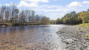 A river with clear water, surrounded by trees and a rocky riverbank. - Enjoy private and pristine access to the Pemigewasset River from THE RIVER VIEW… (Campton)