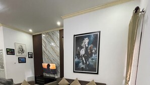 Ein modernes Wohnzimmer mit einem Ecksofa, einem Couchtisch und einem Flachbildfernseher.