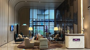 A spacious lobby with a curved ceiling, a reception desk, and a large window offering a view of the outdoors. - Imperial Residence KLCC by Perkasa Ikon (Kuala Lumpur)