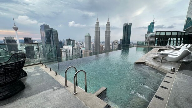 A rooftop infinity pool with a city skyline view, including the Petronas Towers, and modern lounge chairs. - Imperial Residence KLCC by Perkasa Ikon (Kuala Lumpur)