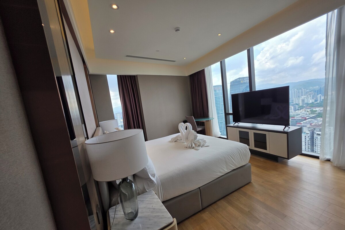 Une chambre d’hôtel moderne dotée d’un grand lit, d’une télévision à écran plat et offrant une vue sur la ville.