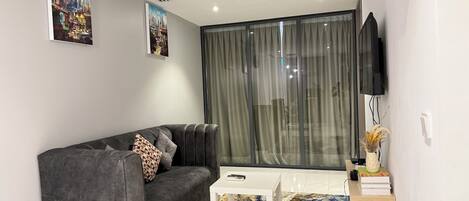 Appartement Deluxe, vue ville | Coin séjour | Télévision LED de 65 pouces avec chaînes numériques, Netflix