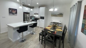 A modern kitchen with white cabinets, a central island, and pendant lighting. - Peaceful 2-bedroom townhome -Sleeps 6 in La Feria (La Feria)