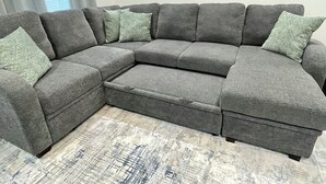 A gray sectional sofa with a low-profile design, positioned on a textured rug. - Peaceful 2-bedroom townhome -Sleeps 6 in La Feria (La Feria)