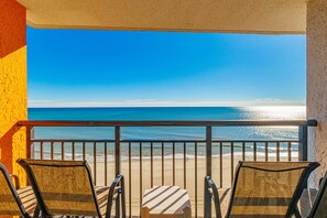 A balcony with a view of the ocean, two chairs, and a small table. - Landmark 1036 (Myrtle Beach)