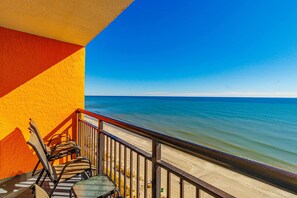 A balcony with chairs and a table overlooking a beach. - Landmark 1430 (Myrtle Beach)